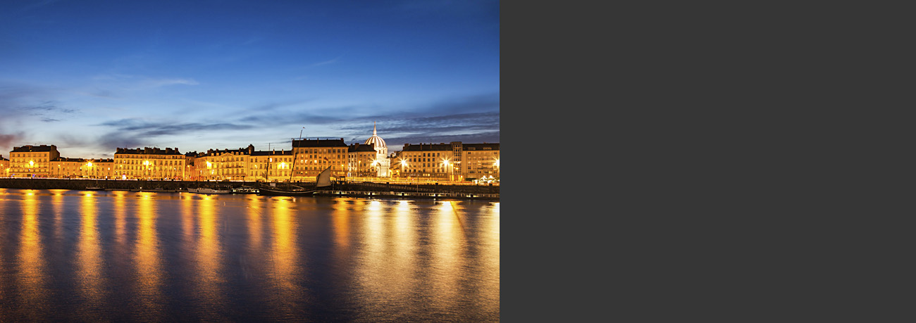 Photo of Nantes, France, with skyline reflecting golden light on the river